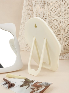 Close-up of cloud-shaped mirror showing the foldable stand and wall-mounting hole