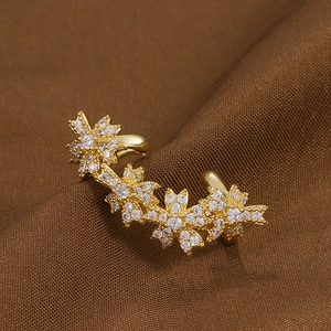Magnifique manchette d'oreille fleurie dorée avec zircons sur fond de velours brun