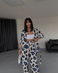 Détail de l'imprimé abstrait bleu et noir sur ensemble chemise manches longues et pantalon blanc