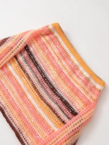 Detail der bunt gestreiften Strickware mit schimmernden Pailletten und Lochmuster