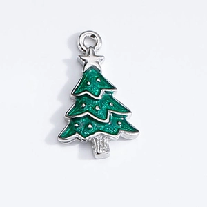 Detail shot of a green enamel Christmas tree pendant with silver metal edges and star