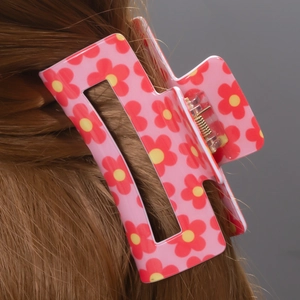Pink rectangular flower claw clip holding long brown hair in a stylish updo hairstyle