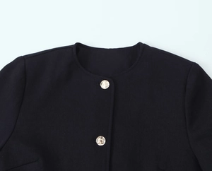 Close-up of black blazer jacket with round neck and decorative golden metal buttons