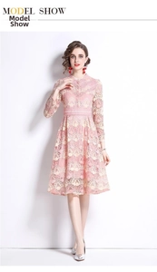 Détail de la broderie en dentelle florale rose et texture crochetée sur robe trapèze