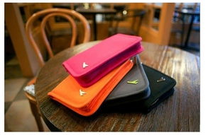 Detail of multi-color travel passport organizers on a wooden table in warm cafe light