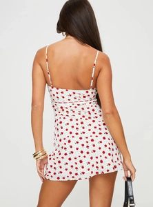 Back view of a white floral mini dress with red roses and thin spaghetti straps