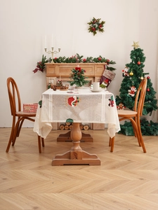 Detailed lace texture with festive Christmas hat and tree embroidery on holiday tablecloth