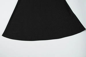 Detailed macro view of the double-stitched hem on the black knitted satin dress fabric