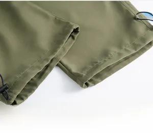 Detalle del dobladillo con cordón ajustable en pantalones cargo verde militar