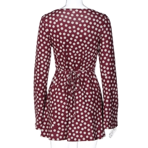 Rear view of long sleeve dark red dress with white polka dots and waist tie detail
