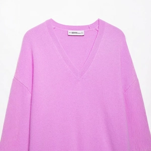 Women's cozy pink V-neck knit sweater with drop shoulders and soft texture in a loose fit