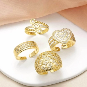 Set of four gold open rings featuring hollow heart patterns and sparkling zircon stones