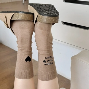 Detail of brown cotton socks featuring black heart embroidery and follow your heart text