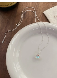 Detailed view of S925 sterling silver chain with iridescent stone pendant and hallmark