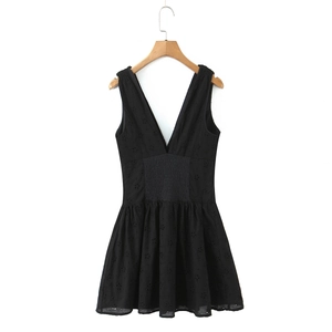 Détail d'une robe noire sans manches à col en V avec broderie creuse et taille élastique