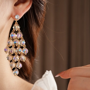 Nahaufnahme von Model mit goldenen Kristall-Ohrringen und elegantem Fransen-Design