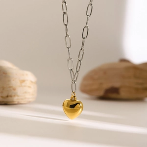 Chic heart pendant necklace with gold heart charm and silver link chain on seashell base