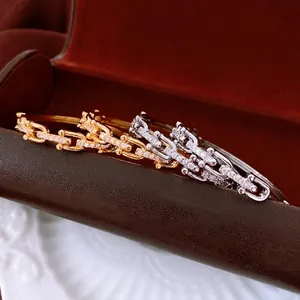 Set of four 18K gold and silver plated chain link bangles with paved zircon stones
