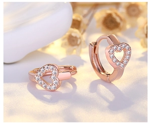 Macro detail of rose gold heart hoop earrings with white micro-pave crystals