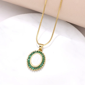 Detalle del colgante Virgen María dorado con circonitas verdes y cadena de serpiente
