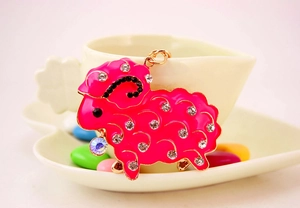 Detail of cute pink sheep keychain with rhinestones on a gold metal chain