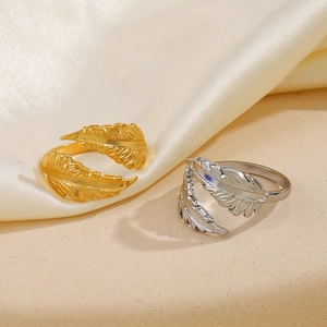 Adjustable stainless steel feather rings in gold and silver finish on silk background