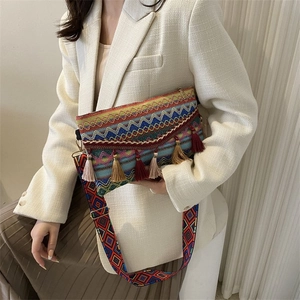 Close-up of a bohemian crossbody bag with colorful woven patterns and tassel charms