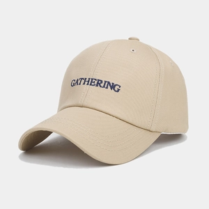 Gros plan sur la broderie GATHERING d'une casquette de baseball beige en sergé de coton