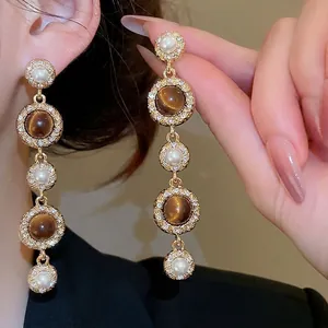 Orecchini vintage a goccia in oro con perle bianche, pietre occhio di gatto e cristalli