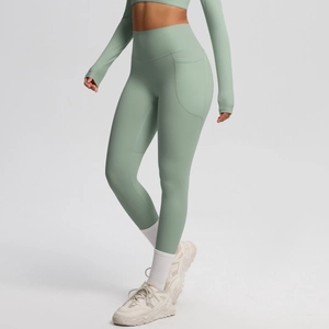 Detail view of high-waist mint green yoga leggings with side pockets and slimming fit
