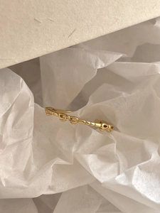 Close-up of golden ribbon bow ring on white tissue paper with soft lighting