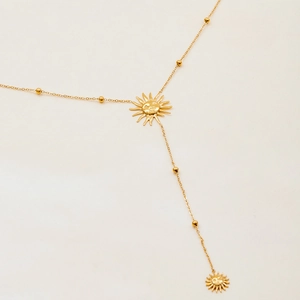 Détail du collier en Y en acier inoxydable plaqué or 18K avec pendentifs soleil et perles