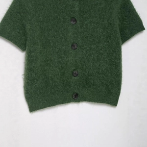 Cardigan in mohair verde scuro a maniche corte con quattro bottoni neri opachi su fondo bianco