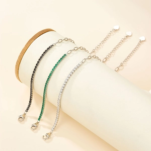 Detailed view of tennis bracelets with black, emerald, and clear cubic zirconia stones