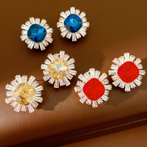 Close-up of vintage sunflower stud earrings with blue yellow and red center stones