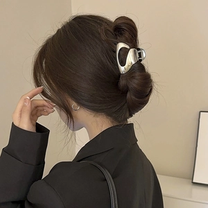 Irregular silver metal hair claw clip for thick hair shown on a female model