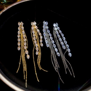 Macro shot of long fringe earrings with crystals and chains in gold and silver finish