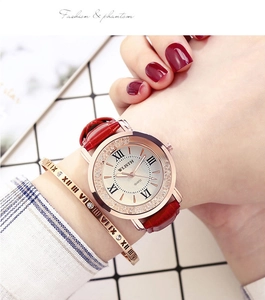 Close-up of women's rose gold quartz watch with red leather strap and matching bracelet