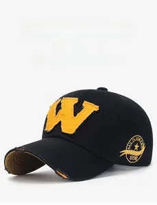 Detail of distressed baseball cap with yellow W patch and side letter embroidery