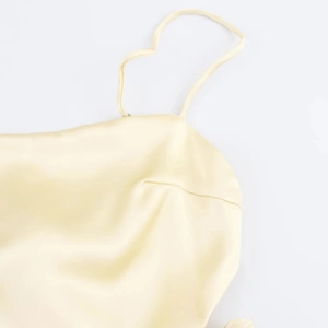 Détail de la robe en satin jaune champagne montrant les bretelles et les coutures fines