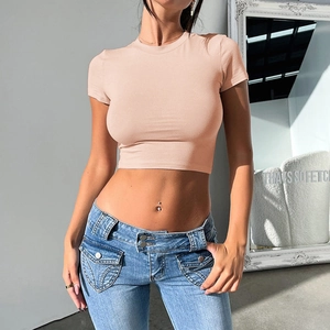 Slim fit pink Y2K cropped t-shirt paired with blue jeans shown on a studio model