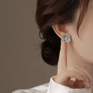 Boucles d'oreilles trèfle avec strass bleus et gemmes rouges sur base dorée