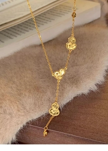 Detailed macro view of 18k gold plated hulu pendants on a vintage style chain