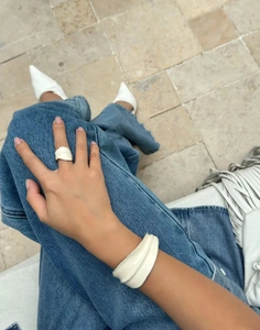 Close-up of modern wide white enamel earrings and bracelet set with matte texture finish