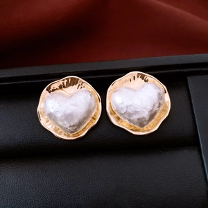 Détail de boucles d'oreilles plaquées or 16 carats avec nacre blanche en forme de cœur