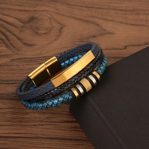 Macro shot of navy blue braided leather bracelet with gold magnetic clasp and metal beads