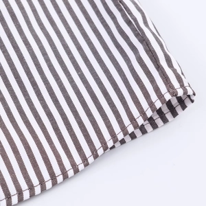 Detail of fine dark brown and beige striped fabric with precise stitching on the hemline