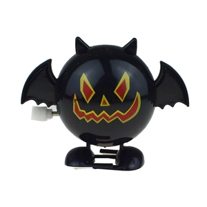 Detail of a wind-up black bat toy for Halloween featuring mechanical knobs and orange teeth