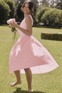 Detail shot of a slim fit pink floral V-neck maxi dress worn in a sunny garden setting