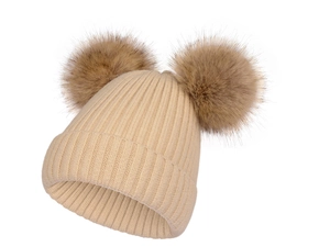 Détails de la maille douce et des deux pompons en fausse fourrure marron sur le bonnet
